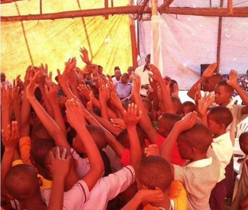 Group of children with raised hands in a community setting