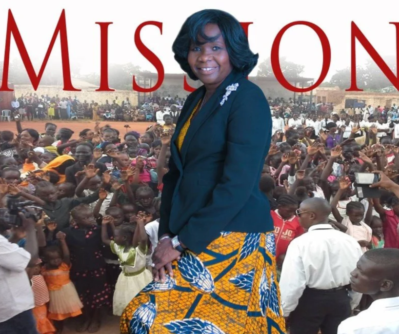 Woman in colorful dress leading crowd in front of MISSION signage